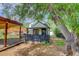 View of the house exterior showing a porch, yard, shed, and mature shade tree at 3429 Avenue D, Kittredge, CO 80457
