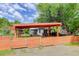 Charming house featuring an orange fence, carport, well-maintained landscaping, and mature trees at 3429 Avenue D, Kittredge, CO 80457