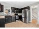 Modern kitchen featuring stainless steel appliances, dark cabinetry, and tile flooring at 3429 Avenue D, Kittredge, CO 80457