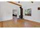 Bright living room with hardwood floors, exposed beams, and a wood burning stove at 3429 Avenue D, Kittredge, CO 80457