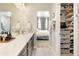 Bright bathroom with a large vanity, walk-in closet, and open doorway to an adjacent bedroom at 1525 W 68Th Ave, Denver, CO 80221
