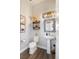 Stylish half bathroom with modern fixtures, industrial decor, and a pedestal sink at 1525 W 68Th Ave, Denver, CO 80221