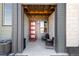 Inviting front entrance with a stylish red door and cozy seating area at 1525 W 68Th Ave, Denver, CO 80221