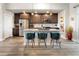 Stylish kitchen island with barstool seating, dark wood cabinets, and granite countertops at 1525 W 68Th Ave, Denver, CO 80221