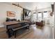 Open-concept living room with hardwood floors, industrial lighting, and fireplace with mounted television at 1525 W 68Th Ave, Denver, CO 80221