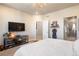 Light-filled main bedroom showcasing a TV, open ensuite bathroom and charming decorative touches at 1525 W 68Th Ave, Denver, CO 80221