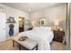 Bright main bedroom featuring an ornate mirror, rustic bedside tables and decor, and ensuite bath at 1525 W 68Th Ave, Denver, CO 80221