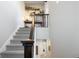 Carpeted staircase with dark wood railing, complemented by decorative shelves and stylish decor at 1525 W 68Th Ave, Denver, CO 80221