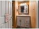 Small bathroom with wooden paneling, vanity, and lighting at 20995 County Road 28, Hudson, CO 80642