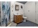 Bathroom with a shower curtain and wooden vanity with light oak cabinets and blue speckled floors at 20995 County Road 28, Hudson, CO 80642