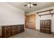 Bedroom with two wooden dressers, ceiling fan and two wooden doors at 20995 County Road 28, Hudson, CO 80642