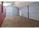 A large gray room with gray carpeting and a red wall, with gray lighting, and a doorway is visible at 20995 County Road 28, Hudson, CO 80642