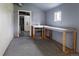 A room with gray walls, a peg board, metal desk, and a stainless sink in the corner next to a back door at 20995 County Road 28, Hudson, CO 80642