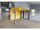 Inside the home, a room is shown with grey walls, a colorful wall and a single column in the middle of the room at 20995 County Road 28, Hudson, CO 80642
