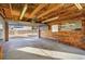 Interior shot of the garage featuring an open garage door, a workbench and a wood-paneled wall at 248 S 5Th Ave, Brighton, CO 80601