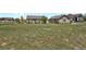 Sprawling backyard with a partial view of the house, lush lawn, and mature trees at 4714 Carmichael Ct, Brighton, CO 80603