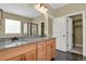 Double sink bathroom with granite countertops, maple cabinetry, large mirror and shower access at 4714 Carmichael Ct, Brighton, CO 80603