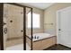 Bathroom with tub, shower, tan tilework, plus a separate toilet room for added privacy at 4714 Carmichael Ct, Brighton, CO 80603