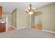 Elegant dining room with a stylish chandelier, neutral carpet, and seamless hardwood flooring transition at 4714 Carmichael Ct, Brighton, CO 80603