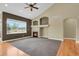 Inviting living room with a cozy fireplace, large window, and a ceiling fan for added comfort at 4714 Carmichael Ct, Brighton, CO 80603