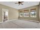 Spacious main bedroom featuring three windows, neutral carpet, ceiling fan, and ensuite bathroom access at 4714 Carmichael Ct, Brighton, CO 80603