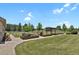 Well-manicured yard showcasing raised garden beds, a pergola, and a sprawling lawn at 4714 Carmichael Ct, Brighton, CO 80603