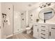 Modern bathroom featuring a tiled walk-in shower and a sleek white vanity with black hardware at 14602 E 2Nd Ave # 200C, Aurora, CO 80011