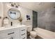 Updated bathroom featuring a modern vanity, round mirror, and a tiled shower-tub combo at 14602 E 2Nd Ave # 200C, Aurora, CO 80011