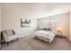 Bright bedroom featuring neutral walls, carpet, a comfortable chair, and a window with blinds at 14602 E 2Nd Ave # 200C, Aurora, CO 80011