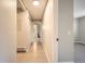 Bright hallway with wood floors leads to a bathroom and room with neutral walls and carpet at 14602 E 2Nd Ave # 200C, Aurora, CO 80011