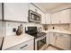 Well-equipped kitchen showcasing stainless steel appliances, marble backsplash, and light gray cabinetry at 14602 E 2Nd Ave # 200C, Aurora, CO 80011