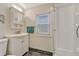 Functional bathroom featuring a vanity, mirror, and shower with natural light from the window at 3201 S Pearl St, Englewood, CO 80113