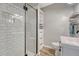 Modern bathroom with a glass shower, white subway tile, and a floating vanity with open shelves at 3201 S Pearl St, Englewood, CO 80113