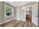 Bright bedroom with wood floors, a window, and a doorway into another room at 3201 S Pearl St, Englewood, CO 80113