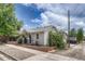 Quaint home with light gray siding, a cozy front porch, and tidy landscaping at 3201 S Pearl St, Englewood, CO 80113