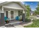 Inviting front porch with cozy blue chairs, potted plants, and a 'Welcome' sign at 3201 S Pearl St, Englewood, CO 80113