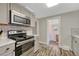 Well-equipped kitchen featuring stainless steel appliances, gray cabinetry, and easy access to other rooms at 3201 S Pearl St, Englewood, CO 80113