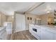 Well-lit kitchen with light wood floors, white countertops, a gas stove, and a door leading outside at 3201 S Pearl St, Englewood, CO 80113