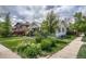 Landscaped front yard showcasing lush greenery and vibrant flowerbeds, with a glimpse of the home at 3201 S Pearl St, Englewood, CO 80113