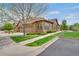 Exterior shot of home featuring manicured lawn, landscaping, and two-car garage at 12348 W Gould Ave, Littleton, CO 80127