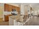 Kitchen with stone countertops and island with seating, modern appliances, and wood cabinets at 12348 W Gould Ave, Littleton, CO 80127