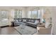Bright living room with large grey sectional sofa, lots of natural light, and wood floors at 12348 W Gould Ave, Littleton, CO 80127