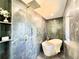 Spa-like bathroom with modern bathtub, large shower head, and vertical tiled walls at 4192 S Vrain St, Denver, CO 80236