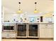 Bright kitchen island featuring modern appliances, wine cooler, and stylish pendant lighting at 4192 S Vrain St, Denver, CO 80236