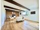 Spacious living room with a brick fireplace, wood-beamed ceiling, and neutral-toned furnishings at 4192 S Vrain St, Denver, CO 80236
