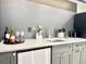 Basement wet bar featuring grey cabinets, stainless steel mini-fridge, and neutral countertop at 4192 S Vrain St, Denver, CO 80236