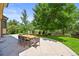 Backyard patio featuring a dining table with seating surrounded by lush green landscaping at 11072 Zephyr St, Broomfield, CO 80021