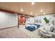 Spacious finished basement with seating area, wooden ceiling beams, and plush carpet at 11072 Zephyr St, Broomfield, CO 80021
