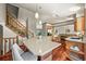 Spacious kitchen island with seating, hardwood floors, and view of the staircase and dining area at 11072 Zephyr St, Broomfield, CO 80021