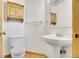 Cozy bathroom featuring a pedestal sink, wood floors, and a mirrored medicine cabinet at 1214 S Akron Way, Denver, CO 80247